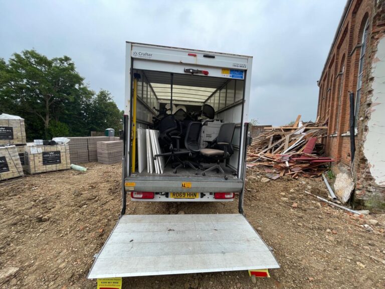 Removal van with its tail lift lowered, loaded with office chairs