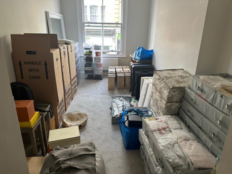 Boxes and packed belongings stacked in a room ready for collection