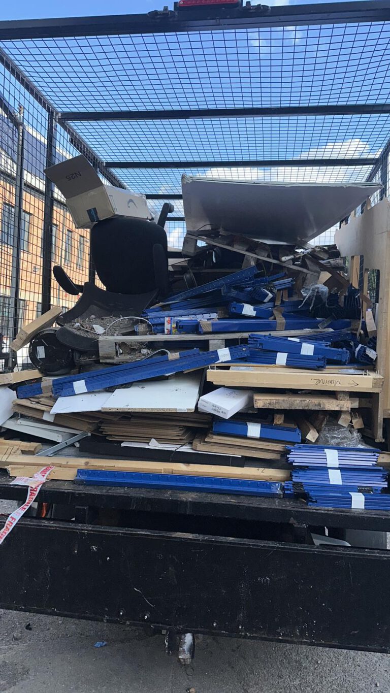 Dismantled office furniture loaded for disposal
