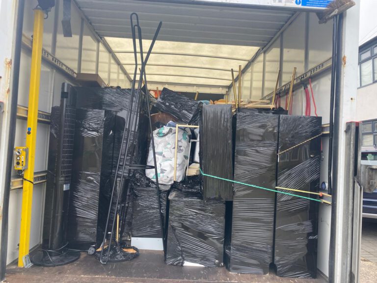 Furniture wrapped in protective film inside a Magnus Removals van