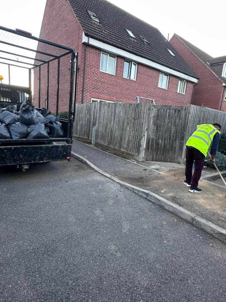 Magnus team member clearing rubbish bags from a driveway