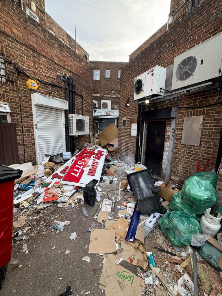 Rear service alley full of commercial waste before clearance