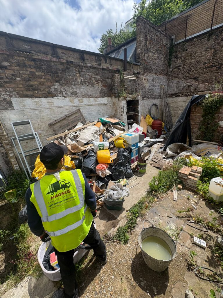 Magnus team member clearing a back yard full of waste